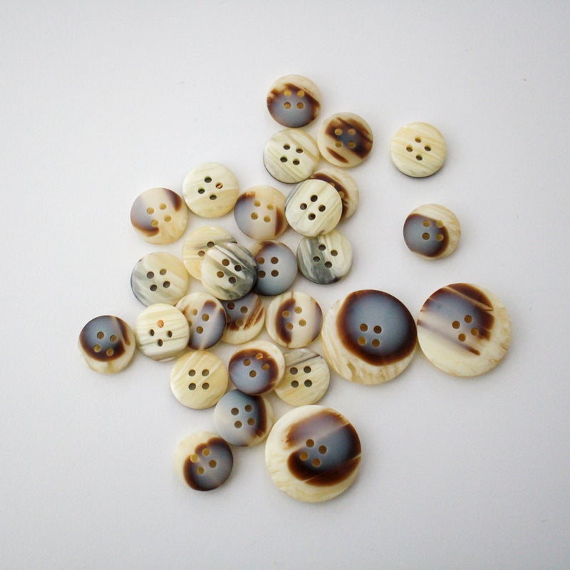 Vaalea kuvioitu muovinappi